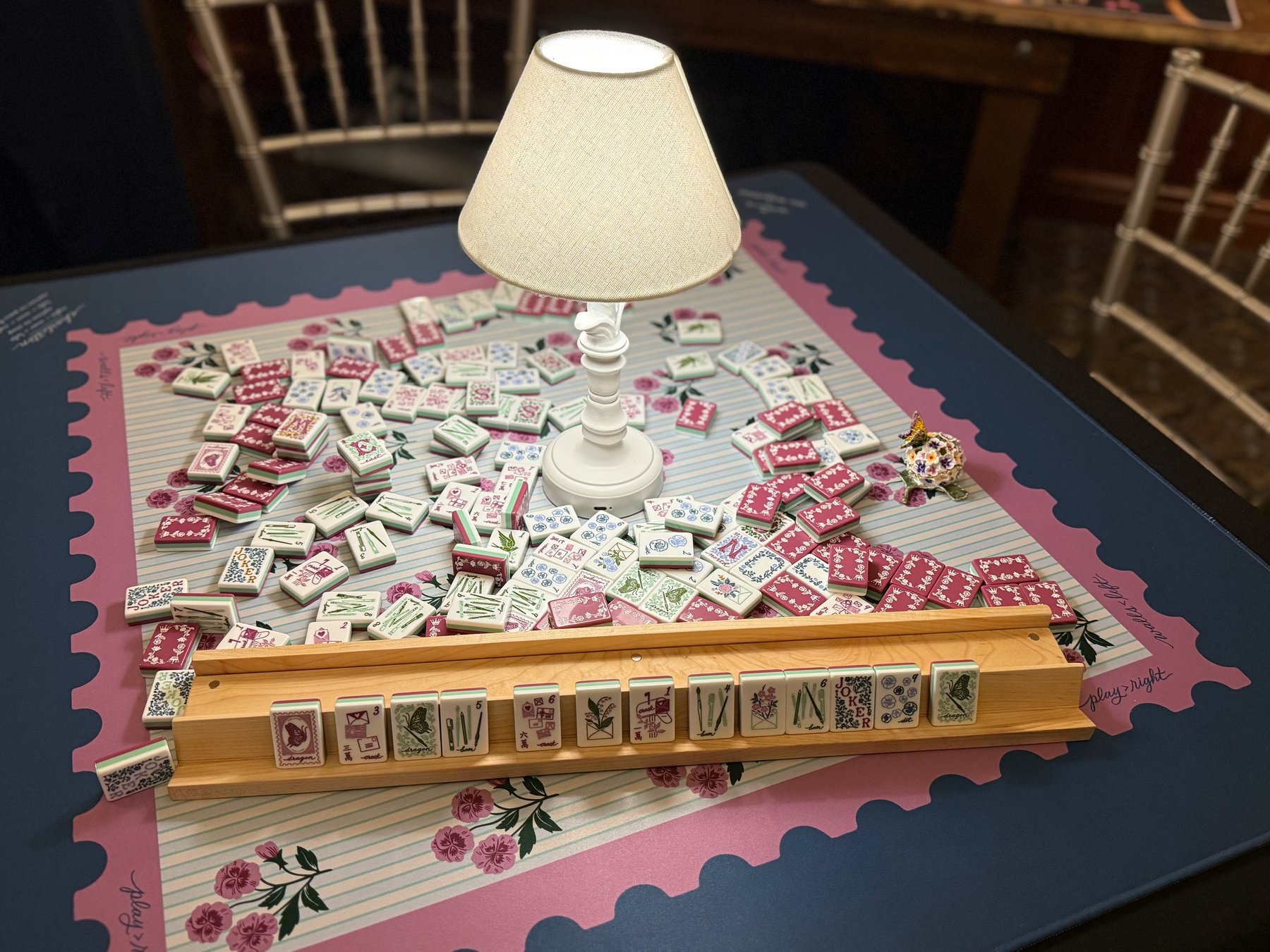 A handcrafted maple Mahjong rack on a dark wood table