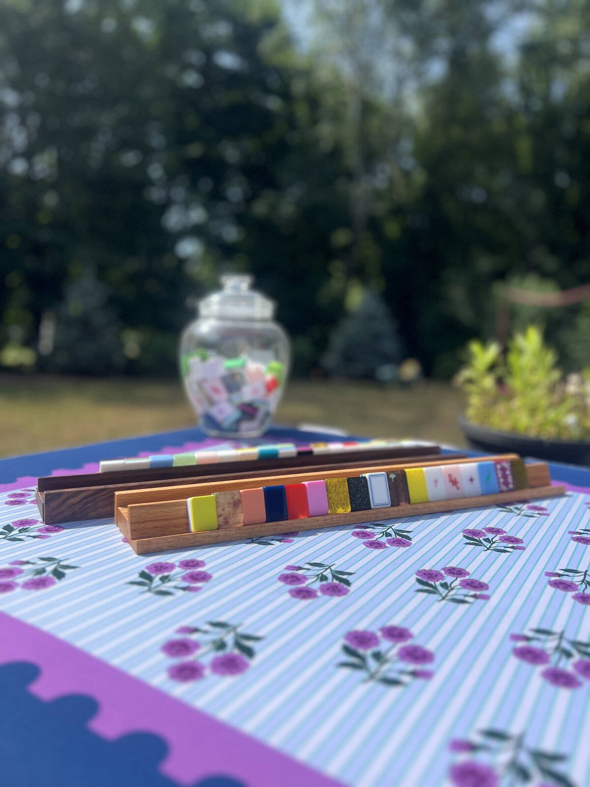 Oak and walnut Mahjong racks set with tiles on an outdoor table
